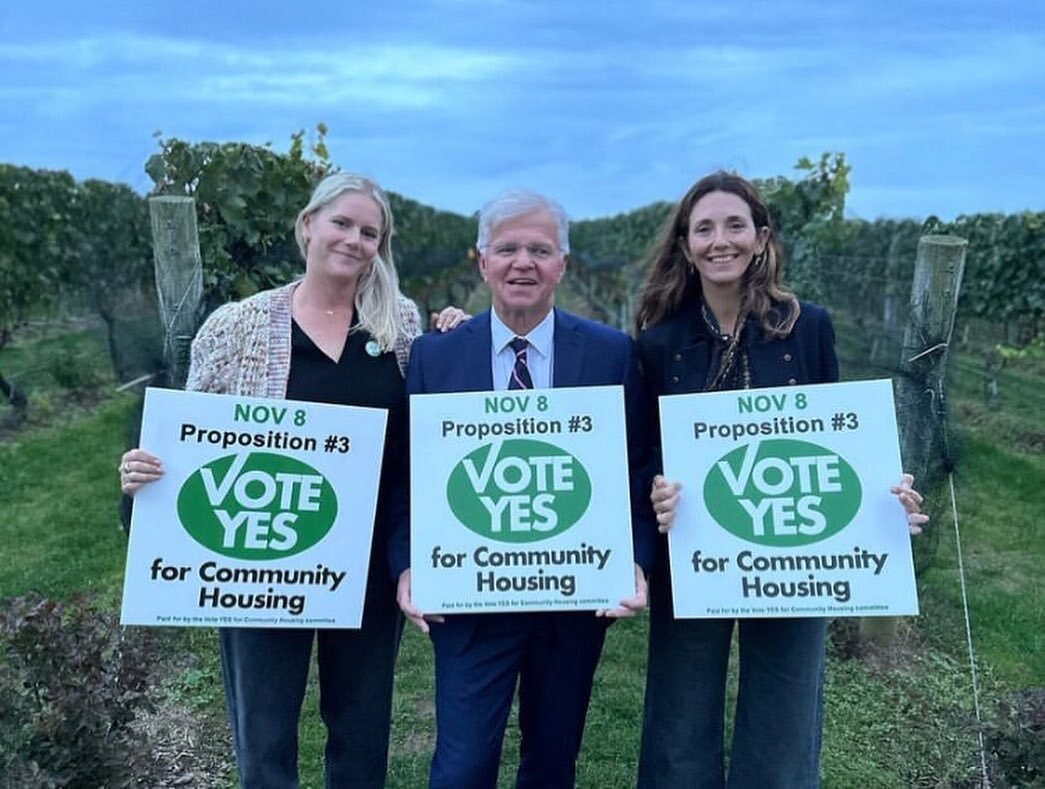 Community members holding Vote Yes for Community Housing signs